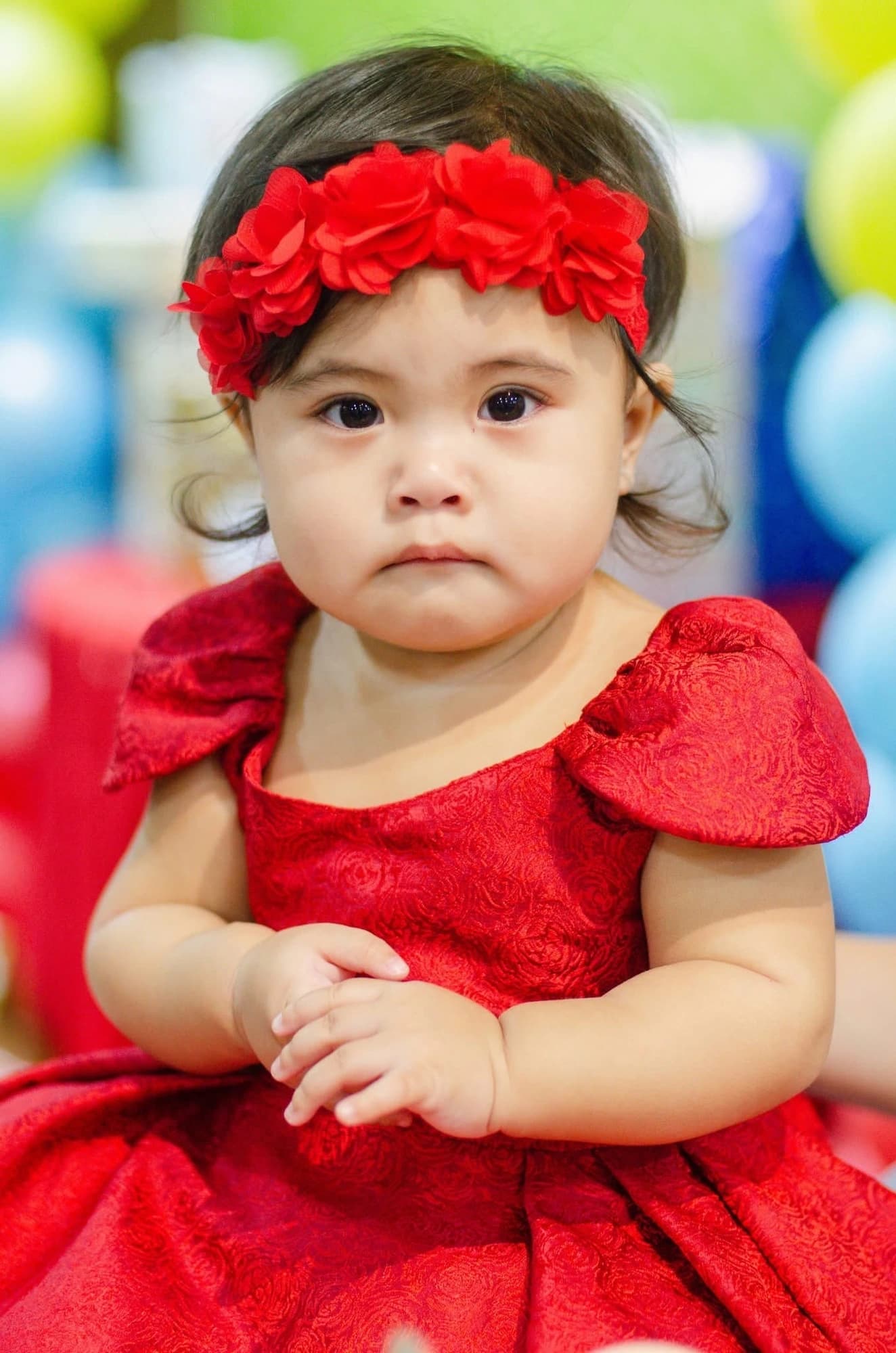 Kiana Lexann wearing a red dress and red floral headband