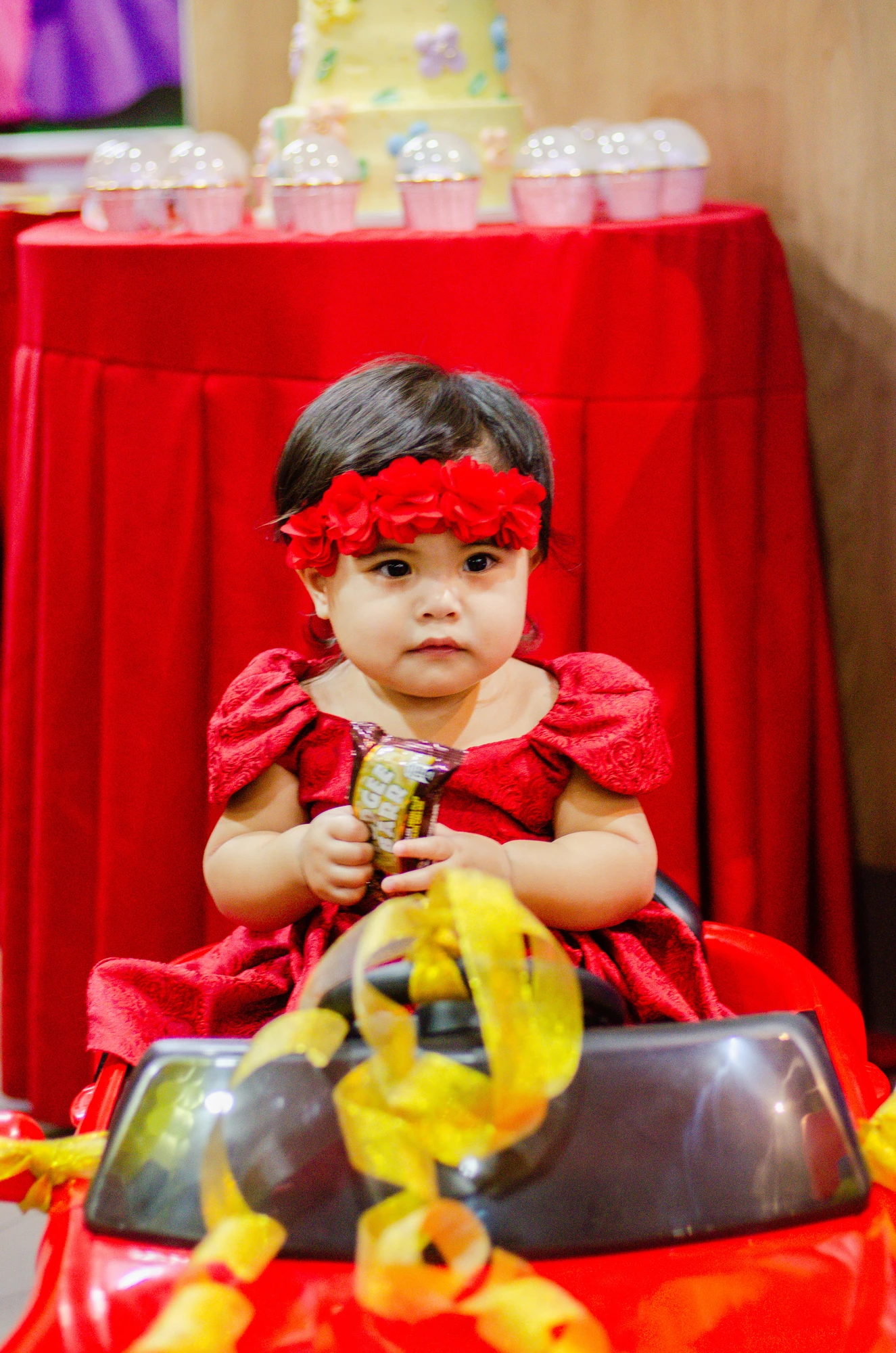 Kiana wearing a red dress and flower headband in her birthday car
